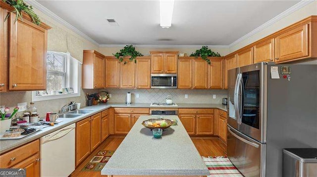 1657 Stilesboro Ridge Dr, Kennesaw, GA 30152 - kitchen with appliances with stainless steel finishes, light countertops, wood finished floors, backsplash, and a center island