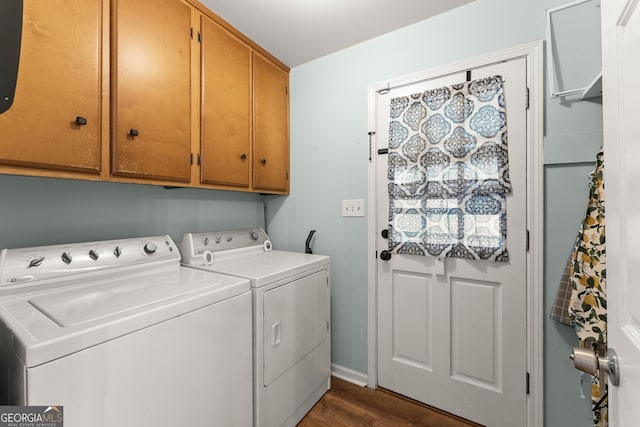 clothes washing area with cabinet space, baseboards, dark wood-type flooring, and washing machine and clothes dryer