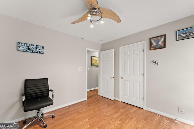 office area with a ceiling fan, light wood-type flooring, and baseboards