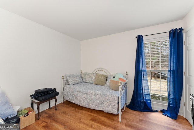 bedroom featuring multiple windows and wood finished floors