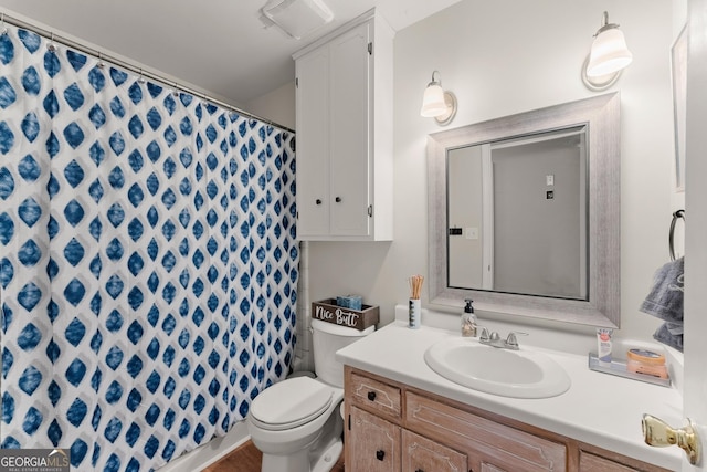 bathroom featuring a shower with shower curtain, vanity, and toilet