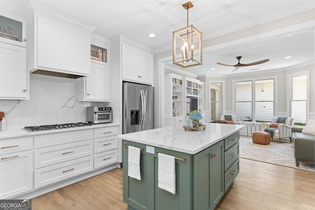 kitchen with white cabinets, appliances with stainless steel finishes, a center island, hanging light fixtures, and green cabinets