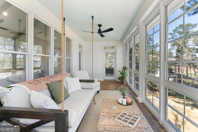 sunroom / solarium with a ceiling fan and a healthy amount of sunlight