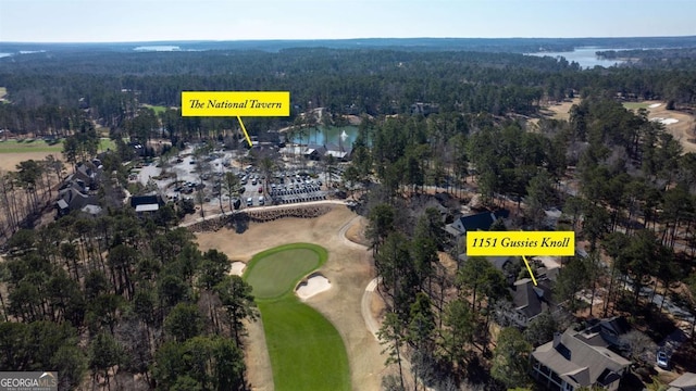 bird's eye view with a water view, a forest view, and view of golf course