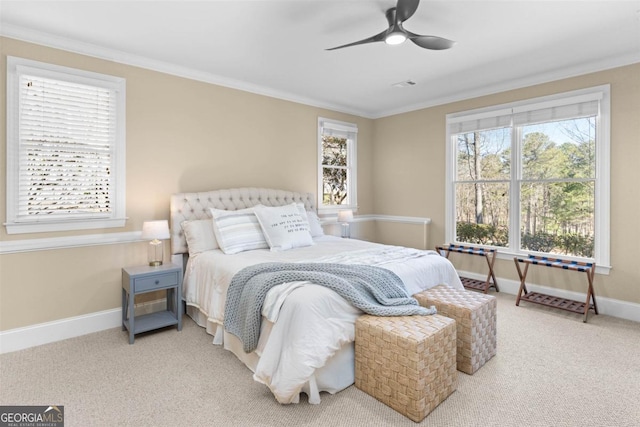 carpeted bedroom with a ceiling fan, baseboards, and crown molding