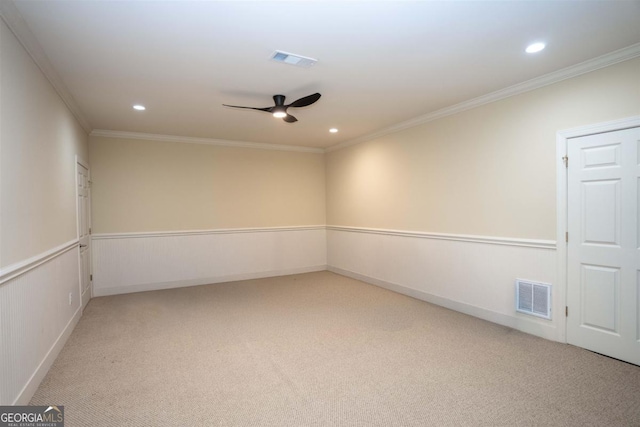 empty room with light colored carpet, visible vents, and crown molding