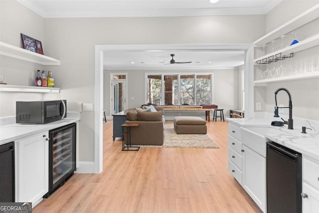 kitchen featuring wine cooler, light stone counters, open shelves, white cabinetry, and black appliances