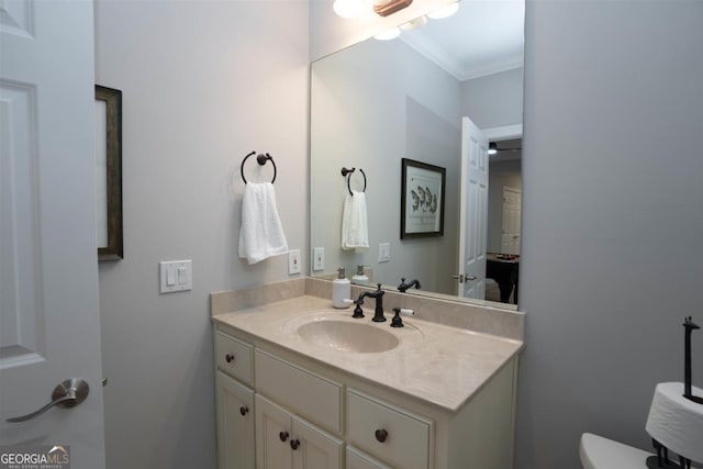 half bath with ornamental molding and vanity