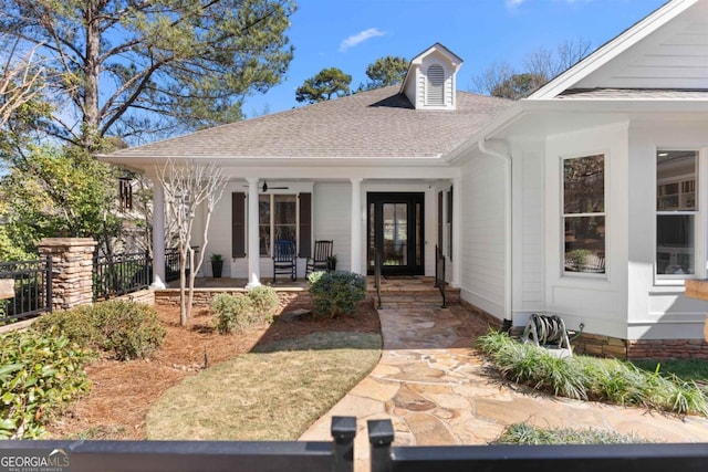 property entrance with covered porch, roof with shingles, and fence