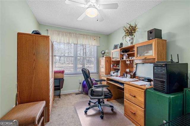 office featuring light colored carpet, ceiling fan, a textured ceiling, and baseboards