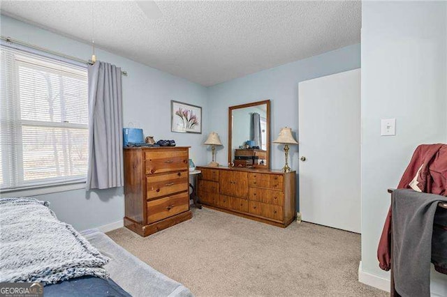 bedroom with light colored carpet and a textured ceiling