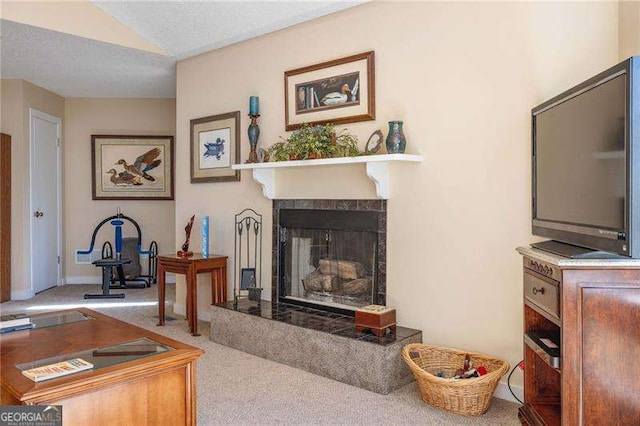 carpeted living room featuring a textured ceiling and a tile fireplace