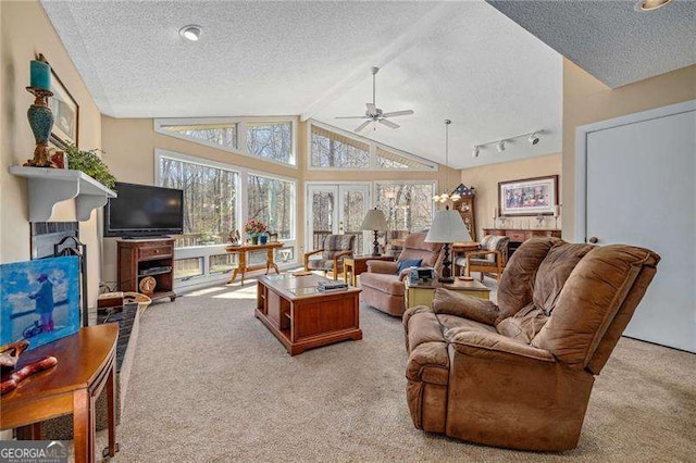 living room with vaulted ceiling with beams, a fireplace, a textured ceiling, and light carpet