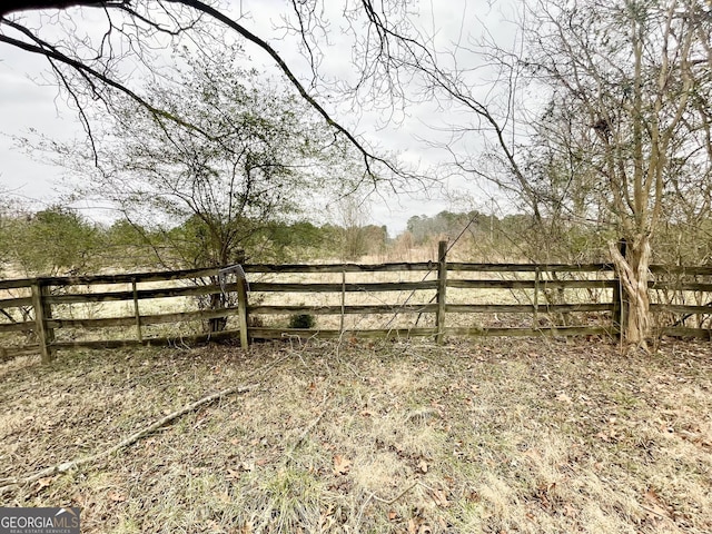 view of yard with a rural view and fence