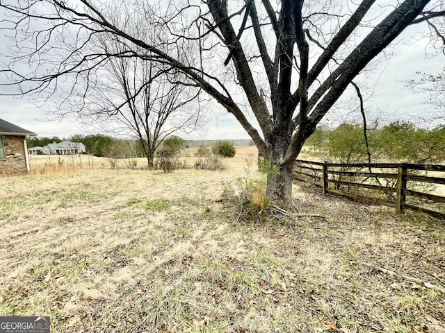 view of yard featuring fence and a rural view