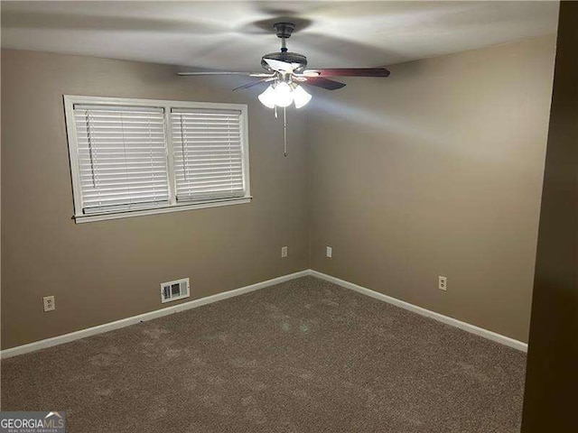 spare room with ceiling fan, carpet, visible vents, and baseboards