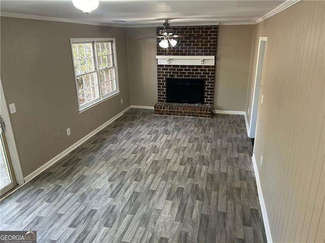 unfurnished living room featuring ornamental molding, dark wood-type flooring, a fireplace, and baseboards