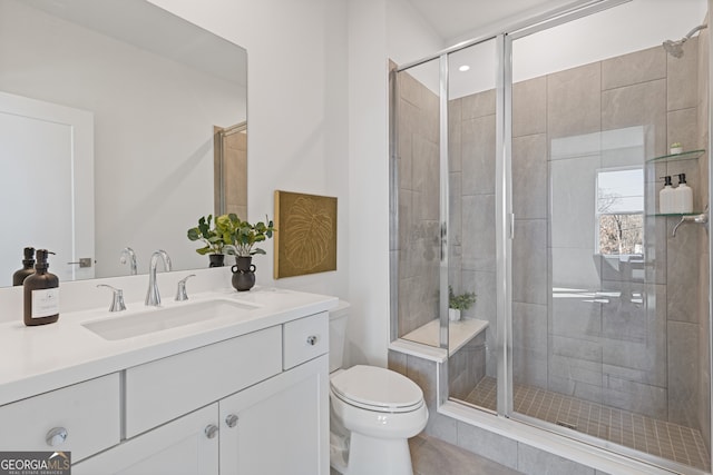 bathroom with vanity, a shower stall, and toilet