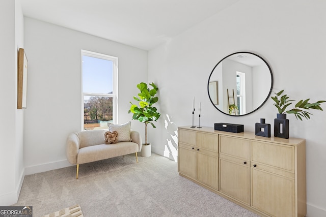 living area with light carpet and baseboards