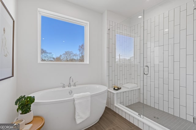 bathroom with a stall shower and a soaking tub