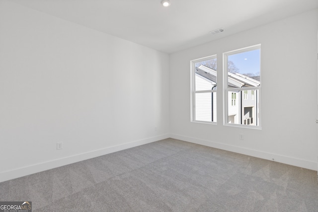 unfurnished room featuring light carpet, visible vents, and baseboards