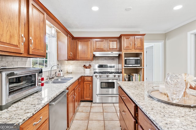 kitchen with stainless steel appliances, backsplash, a sink, and under cabinet range hood