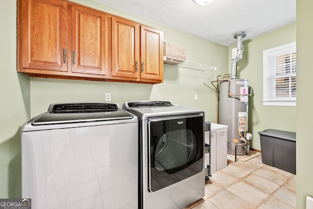 laundry area with water heater, separate washer and dryer, a textured ceiling, and cabinet space