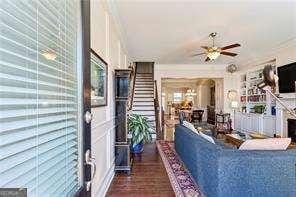 living room with ceiling fan and stairway