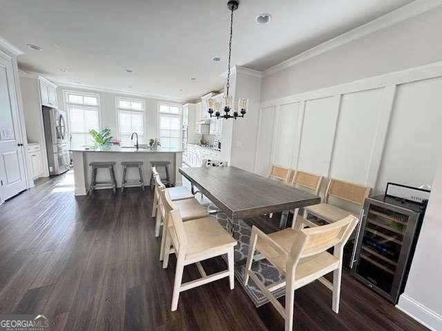 dining room with wine cooler, a decorative wall, dark wood-style flooring, ornamental molding, and an inviting chandelier