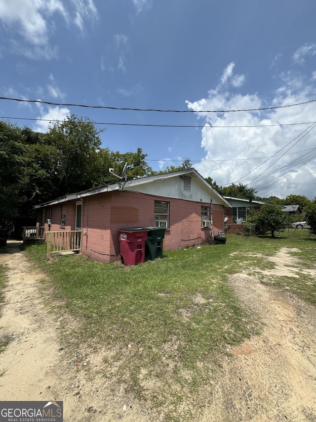 view of side of property with concrete block siding and a yard