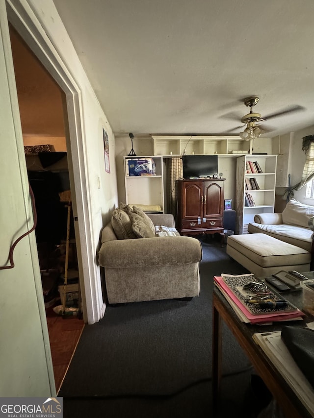 living room with ceiling fan and dark carpet