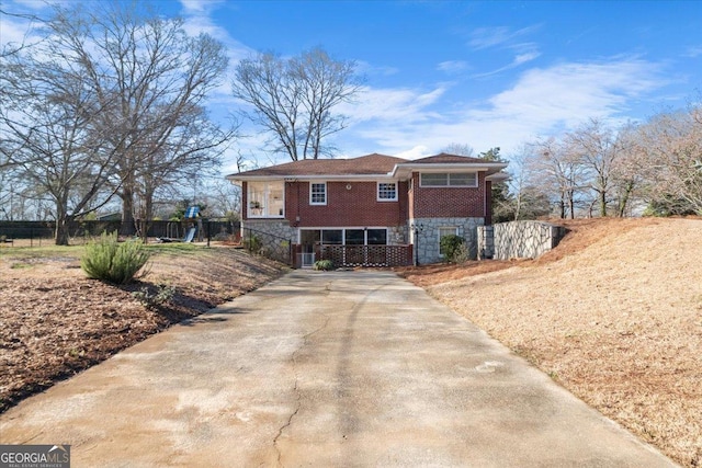 view of front of property with brick siding and fence