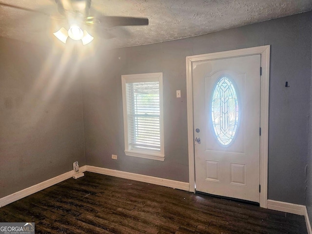 foyer featuring a textured ceiling, dark wood finished floors, a ceiling fan, and baseboards