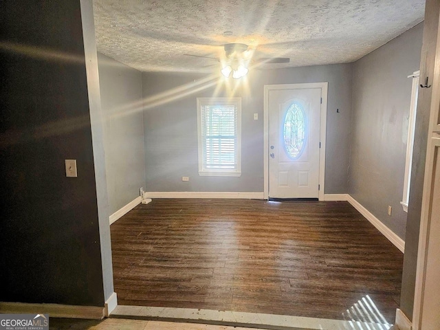 foyer entrance featuring ceiling fan, a textured ceiling, baseboards, and wood finished floors