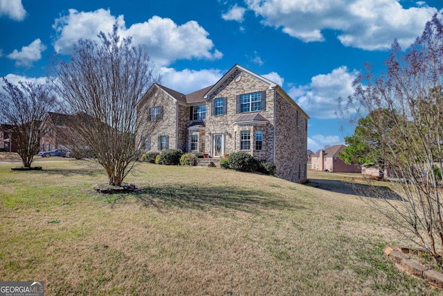 traditional-style house with stone siding and a front lawn