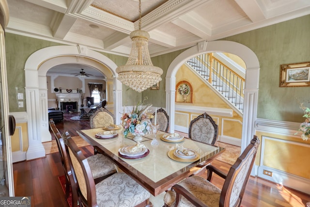 dining area featuring arched walkways, beam ceiling, a fireplace, and a decorative wall