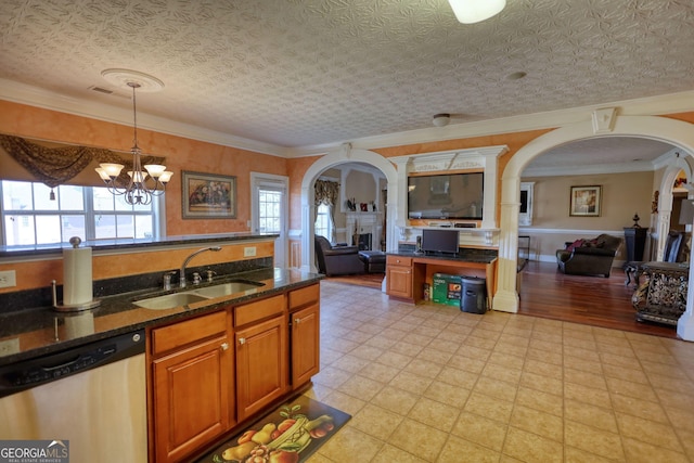 kitchen featuring pendant lighting, brown cabinets, stainless steel dishwasher, open floor plan, and a sink