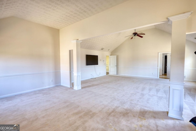 unfurnished living room featuring a textured ceiling, high vaulted ceiling, light colored carpet, a ceiling fan, and decorative columns