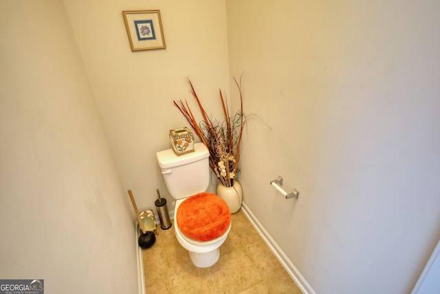 bathroom with toilet, baseboards, and tile patterned floors