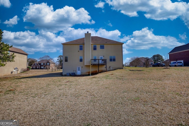 rear view of property with a residential view, a yard, and a chimney