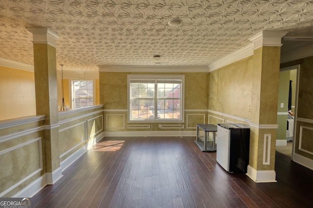 spare room featuring dark wood-style floors, an ornate ceiling, and crown molding