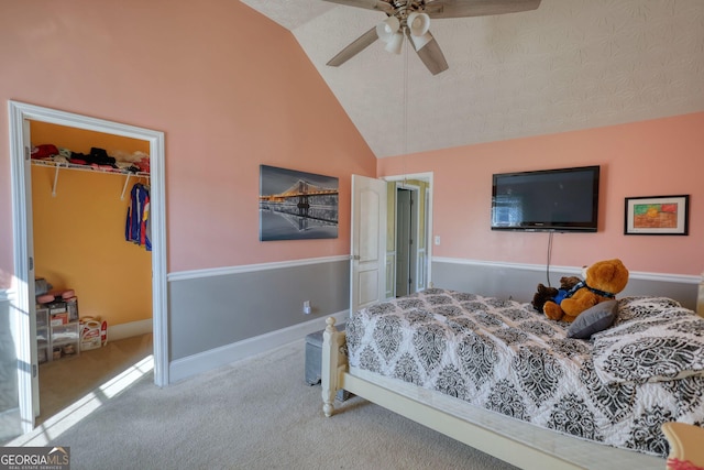 carpeted bedroom with lofted ceiling, a ceiling fan, baseboards, a spacious closet, and a closet