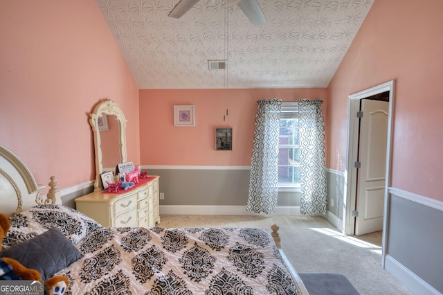 bedroom with a textured ceiling, light carpet, visible vents, baseboards, and vaulted ceiling