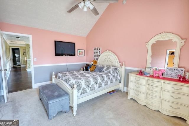 bedroom featuring light colored carpet, vaulted ceiling, baseboards, and ceiling fan