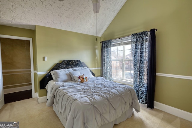 bedroom with lofted ceiling, baseboards, and light colored carpet