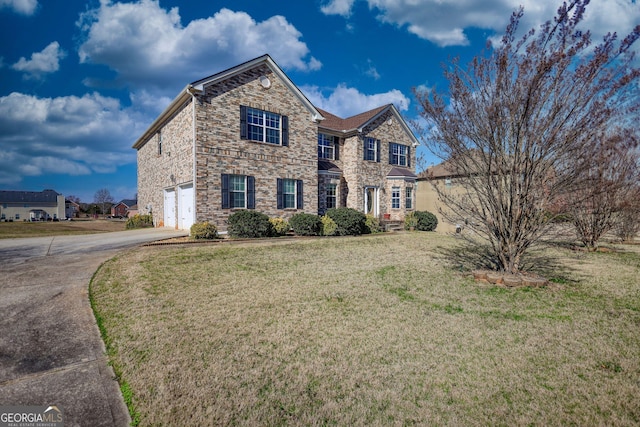 traditional home featuring a garage, a front yard, stone siding, and driveway