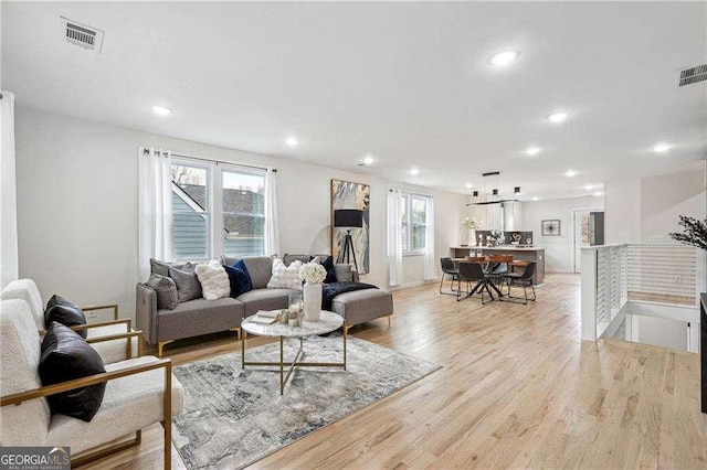 living area featuring recessed lighting, visible vents, and light wood-style floors