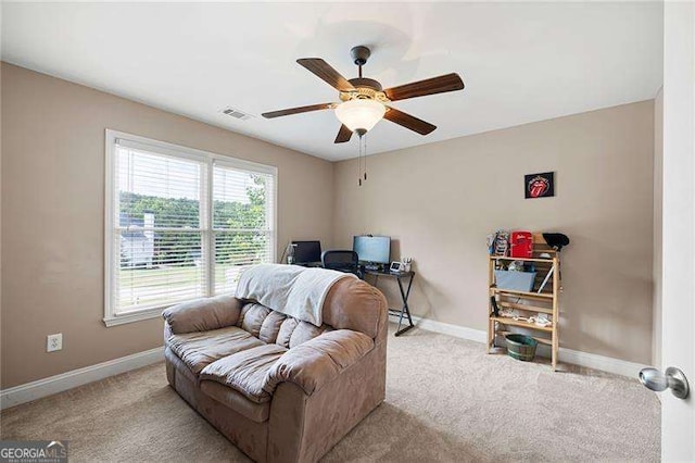 office space with visible vents, baseboards, a ceiling fan, and light colored carpet