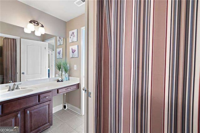 bathroom featuring visible vents, baseboards, vanity, and tile patterned floors