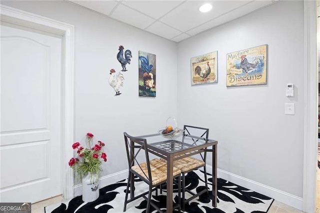 dining space with a drop ceiling and baseboards